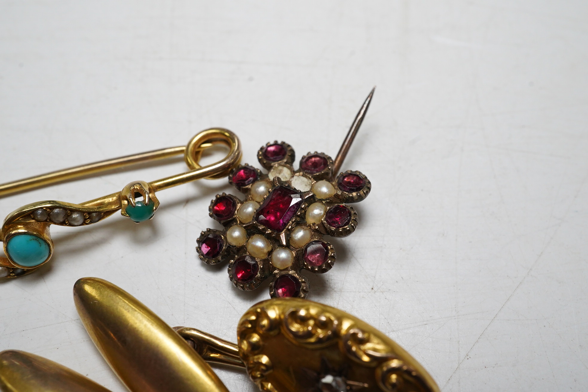 A 15ct gold split pearl and turquoise bar brooch, gross 1.9 grams, a pair unmarked yellow metal cufflinks, each set with an old cut diamond, gross 4.3 grams and an early Victorian garnet and pearl set mourning brooch. Co